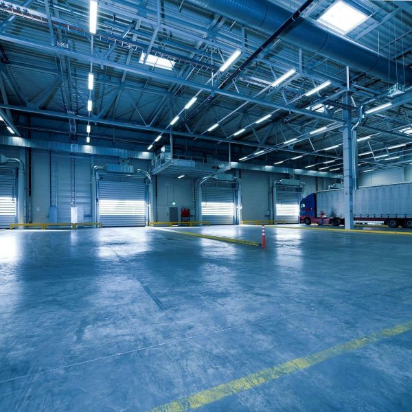 Large warehouse interior with docked truck, ideal for logistics and warehousing.